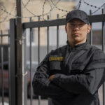 portrait-male-security-guard-with-barbed-wire-fence